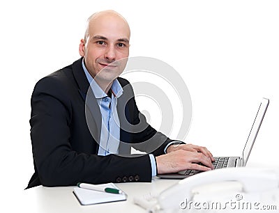 Businessman sitting at desk, working on laptop computer Stock Photo