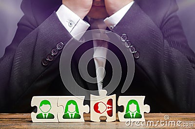 Businessman sitting in despair over the not assembled puzzles symbolizing a team of employees. Toxic or incompetent worker Stock Photo