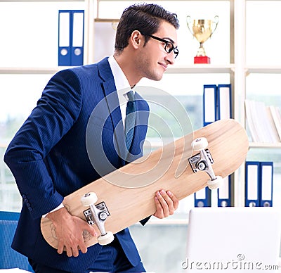 Businessman with skateboard in office Stock Photo