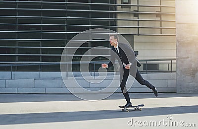 Businessman on a skateboard in urban area Stock Photo