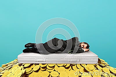 Businessman sleeps serene over a pile of golden coins. concept of wealth and good investment Stock Photo