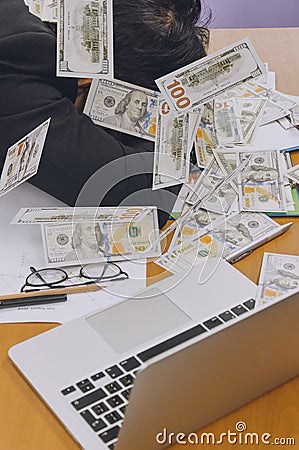 Businessman slepping with heap of dollar money in office Stock Photo