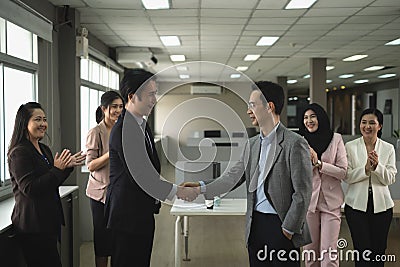 Businessman in smart office suit shaking their hands with partners and secretary team of both sides after successfully negotiated Stock Photo