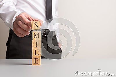 Businessman stacking wooden cubes to spell the word Smile Stock Photo