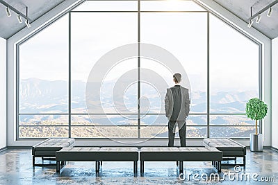 Businessman standinf in minimalistic attic interior room Stock Photo