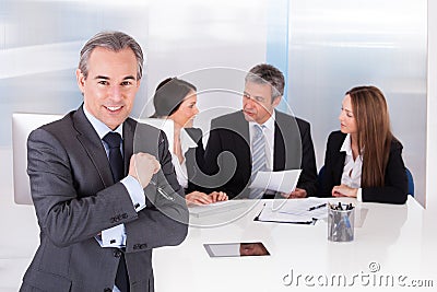 Businessman standing in front of his colleagues Stock Photo