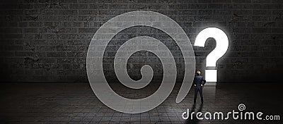 Businessman standing in front of a portal shaped as a questionmark Stock Photo