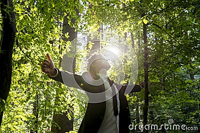 Businessman standing with his arms outspread in woodland Stock Photo