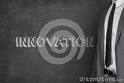 Businessman Standing By Innovation Text On Blackboard Stock Photo