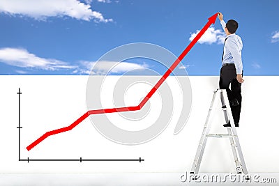 Businessman standing on ladder drawing global diagrams Stock Photo