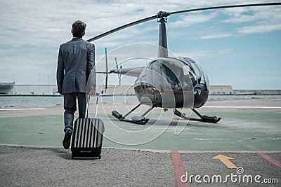 Businessman standing near private helicopter Stock Photo