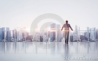 Businessman standing on a roof and looking at Stock Photo