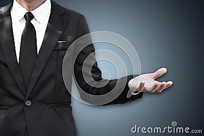 Businessman standing and shows outstretched hand with open palm Stock Photo