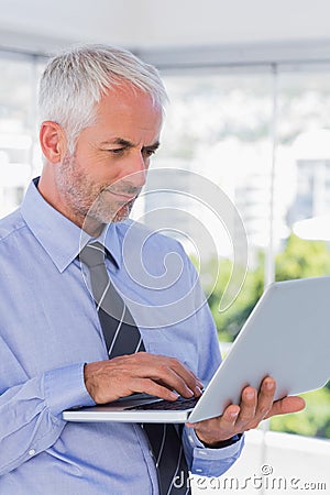 Businessman standing and using laptop Stock Photo