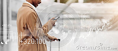 A businessman in a stylish camel coat uses his smartphone at the airport Stock Photo
