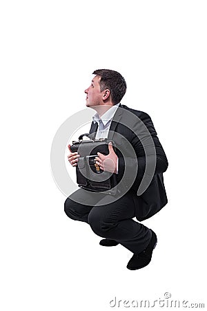 Businessman in a suit with a briefcase in his hands crouched down isolated on white background. Stock Photo