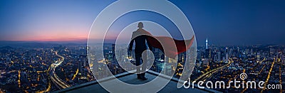 Businessman in suit and cape hero stand at rooftop looking great cityscape Stock Photo