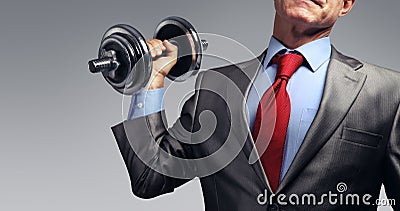 Businessman in suit raising dumbbell. Tax burden concept Stock Photo