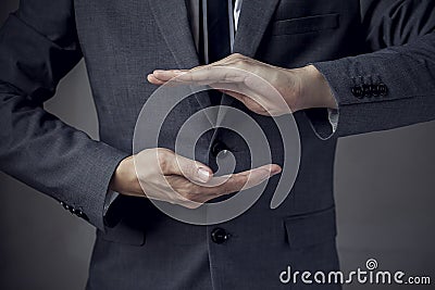 Businessman in suit with two hands in position to protect something Stock Photo