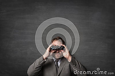 Businessman in a suit watching with binoculars Stock Photo