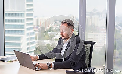 Businessman in suit working on laptop Stock Photo