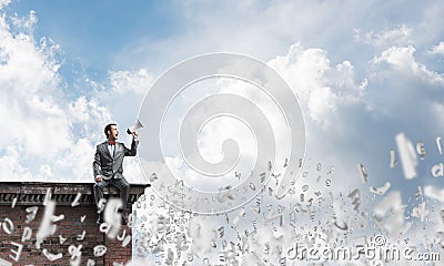 Businessman in summer park announcing something in loudspeaker and symbols fly around Stock Photo