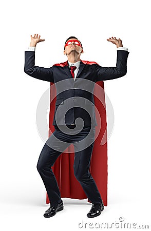 A businessman in superhero costume over his suit trying to hold a heavy invisible heavy object from above. Stock Photo