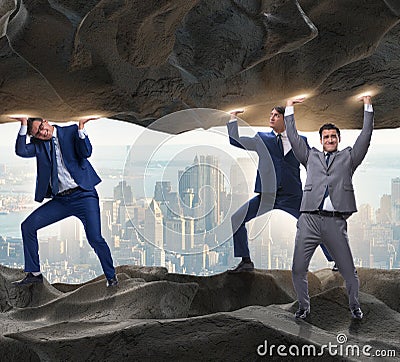 Businessman supporting stone under pressure Stock Photo