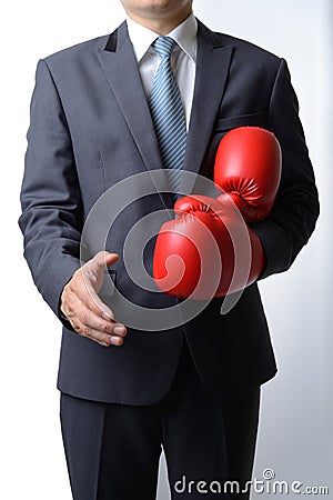 Businessman take off boxing gloves to offer a handshake on white Stock Photo