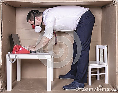 Businessman takes a strange work position Stock Photo