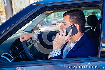 Businessman talking on his phone while driving his city car in the traffic jam Stock Photo