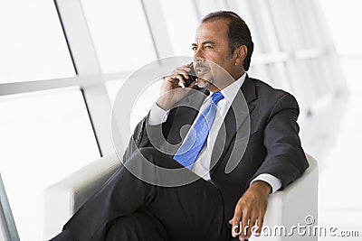 Businessman talking on mobile phone in lobby Stock Photo