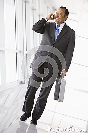 Businessman talking on mobile phone in lobby Stock Photo