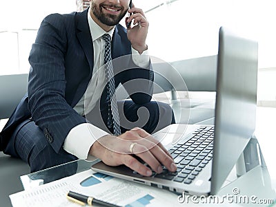 Foreground businessman talking on a smartphone Stock Photo
