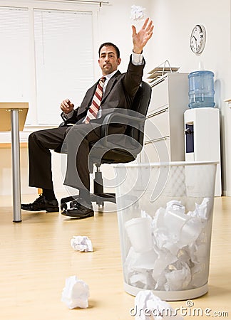 Businessman throwing paper in trash basket Stock Photo