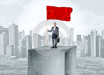 Businessman on the top of the city holding flag Stock Photo