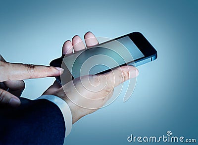 Businessman touch press mobile smart phone smart phone on blue background Stock Photo