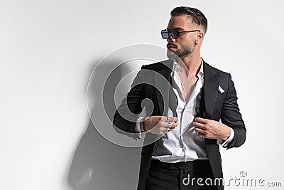 Businessman with tough attitude is holding his undone bowtie Stock Photo