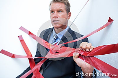 Businessman trapped by red tape Stock Photo