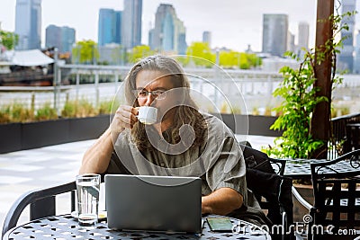 Businessman traveling, working in New York City hands holding cup of coffee, working on laptop Stock Photo