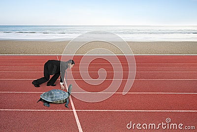 Businessman and turtle are ready to race on running track Stock Photo