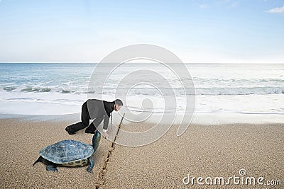 Businessman and turtle are ready to race on sand beach Stock Photo