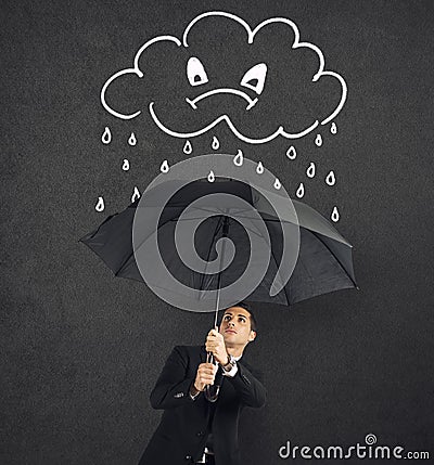 Businessman with umbrella and a angry cloud with rain. Concept of crisis and financial trouble Stock Photo