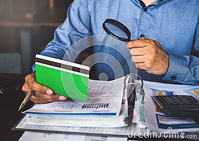 Businessman use Magnifying glass and calculator to find something in account book Stock Photo