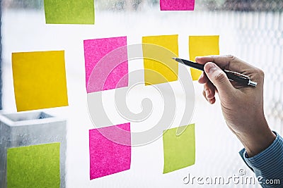 Businessman use post it notes to planning idea and business marketing strategy, Sticky note on glass wall Stock Photo