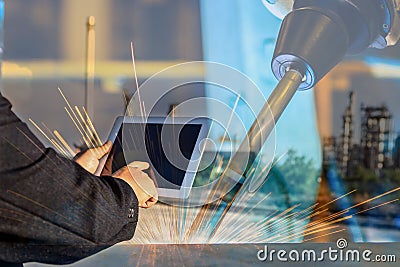 Businessman is used tablet control automate wireless Robot welding. Stock Photo