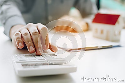 Businessman using calculator calculate budget about house contract mortgage in the office room Stock Photo