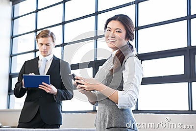 Businessman using digital tablet and businesswoman using mobile phone Stock Photo