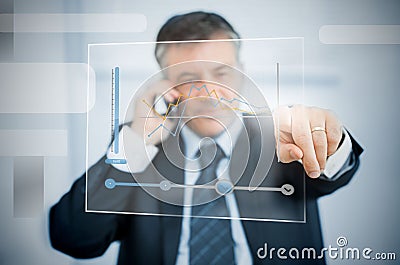 Businessman using futuristic touchscreen to view graph Stock Photo