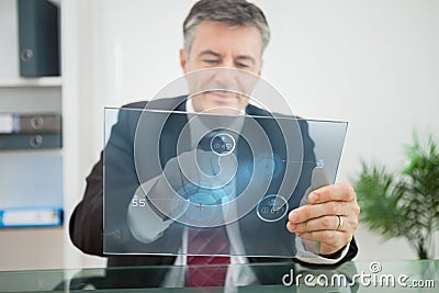 Businessman using futuristic touchscreen to view statistics Stock Photo